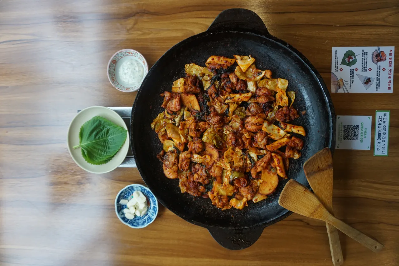 위에서 내려다본 무쇠 철판 위 직화 닭갈비와 반찬